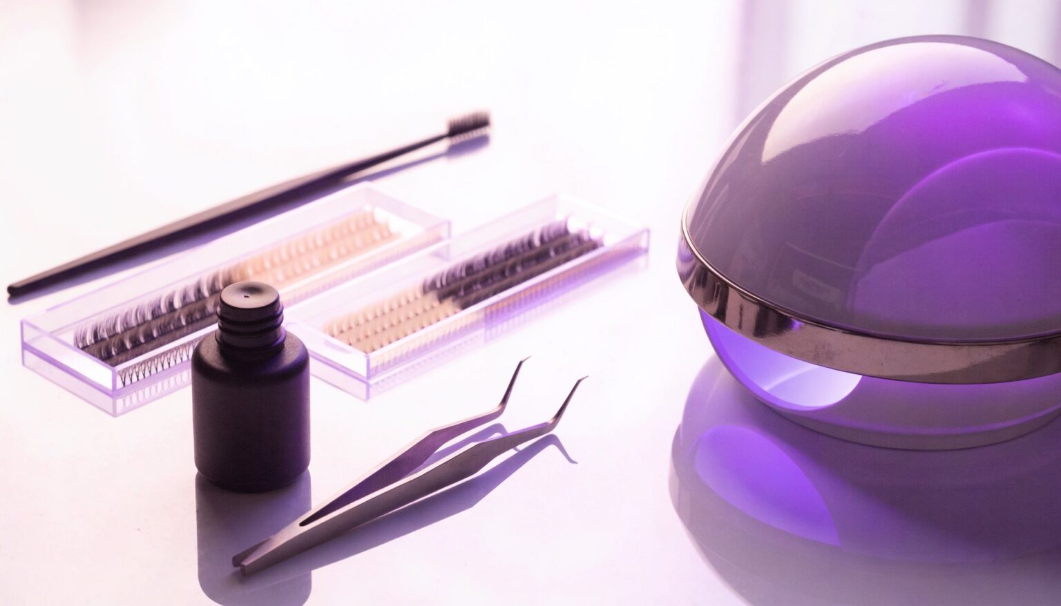 Lash-Arbeitsplatz mit UV-/LED-Aushärtelampe, Kleber und Pinzette – lichthärtender UV-Wimpernkleber