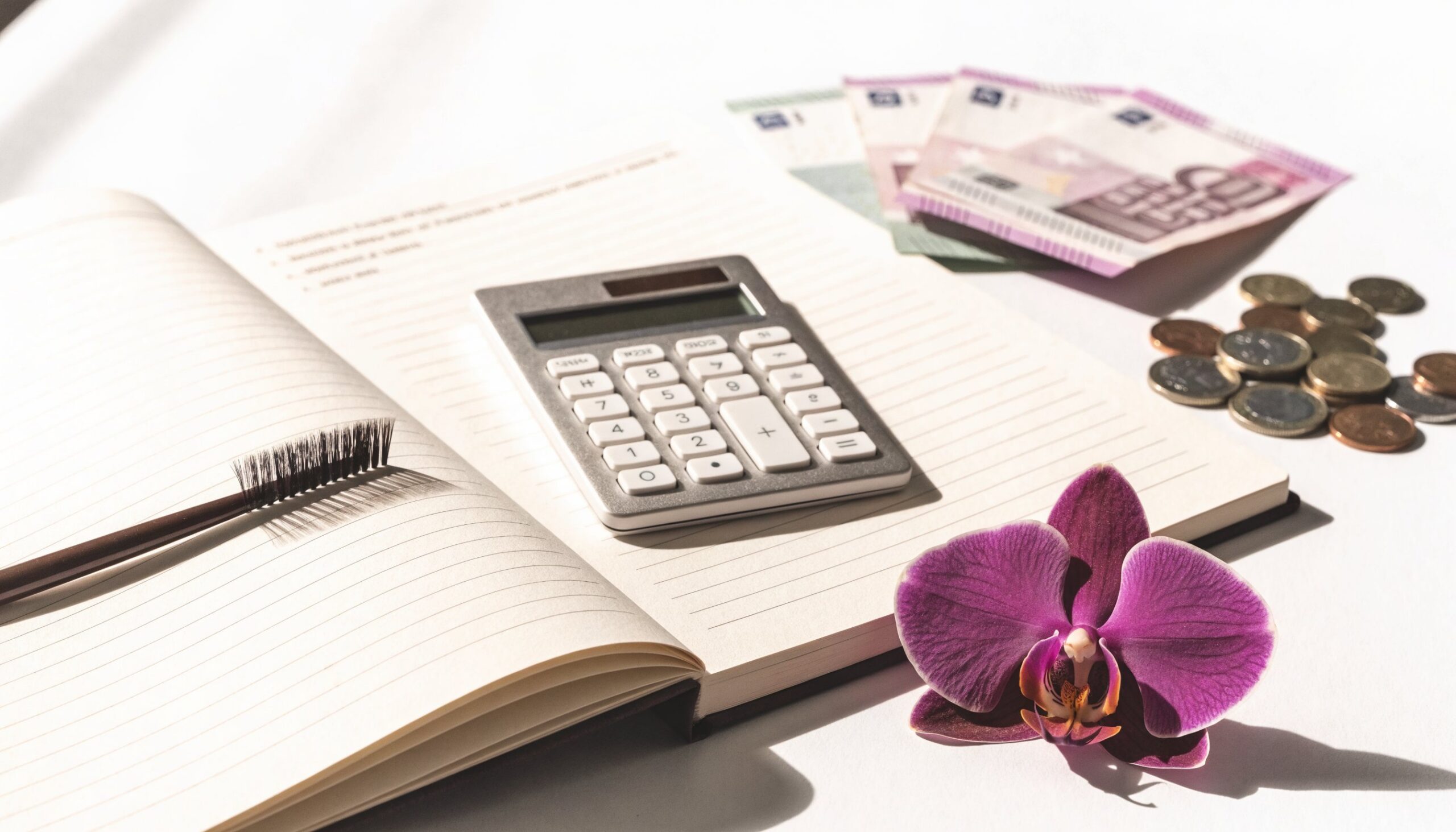 Notizbuch, Taschenrechner und Euro-Geld zum Thema Ausbildung finanzieren
