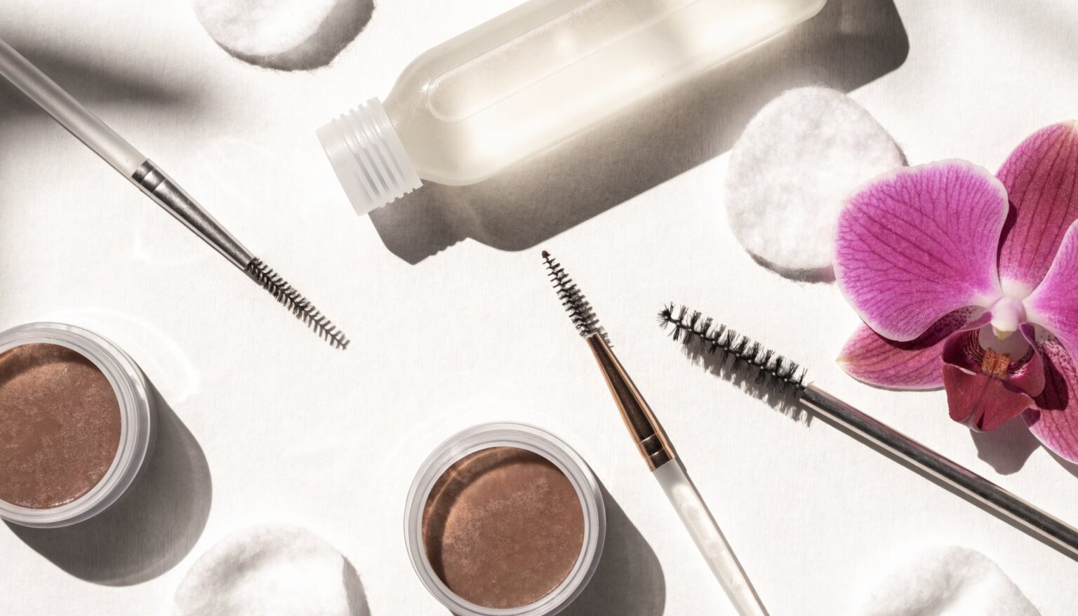 Brow-Lamination-Werkzeuge und Augenbrauen-Styling auf hellem Untergrund