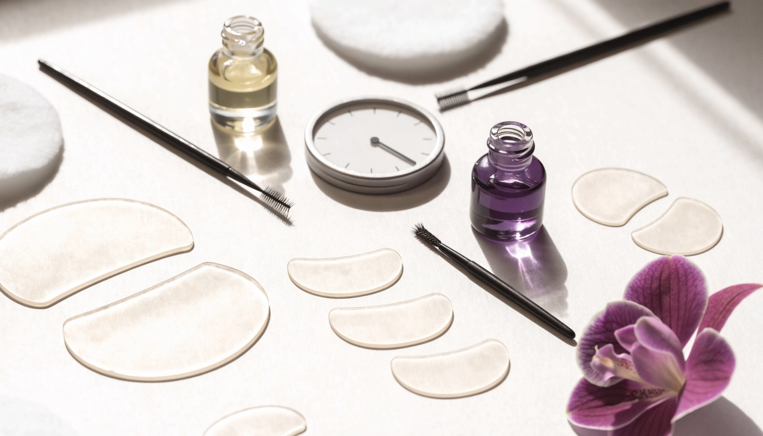 Lash-Lift-Set mit Silikon-Pads, Bürstchen und Lotion auf hellem Untergrund